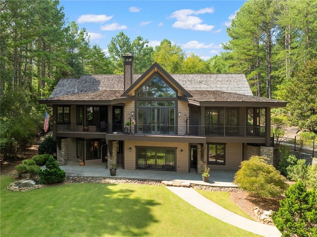 back of property with a lawn and a patio