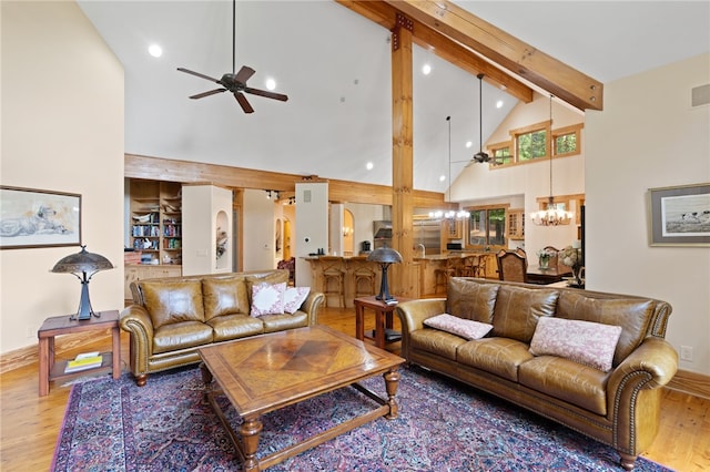 living room featuring high vaulted ceiling, beamed ceiling, ceiling fan with notable chandelier, and hardwood / wood-style floors