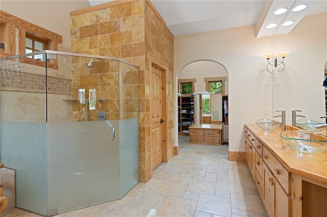 bathroom with walk in shower, vanity, tile walls, and a wealth of natural light