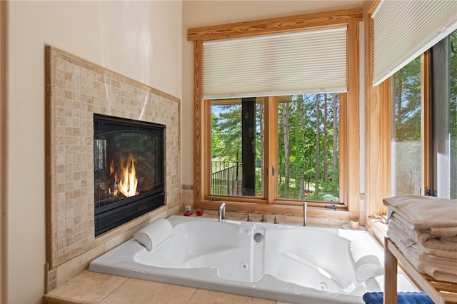 bathroom featuring tiled tub and a tiled fireplace