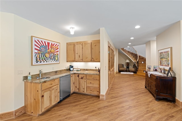 kitchen with light stone countertops, dishwasher, light wood-type flooring, light brown cabinetry, and sink