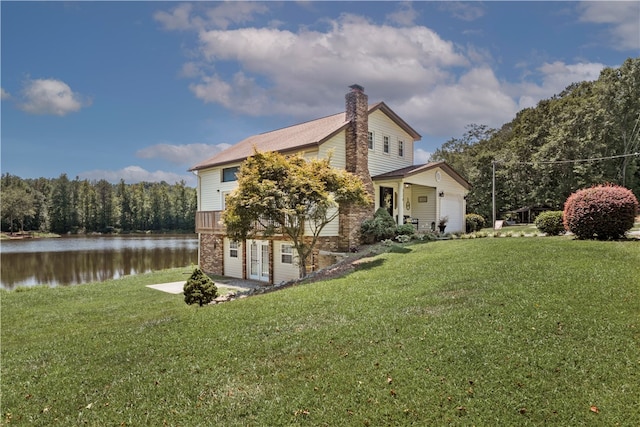 view of side of property with a yard and a water view