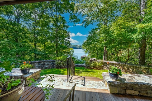 wooden terrace with a patio area, a lawn, and a water view