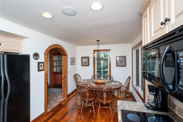 dining area featuring an inviting chandelier and dark hardwood / wood-style floors