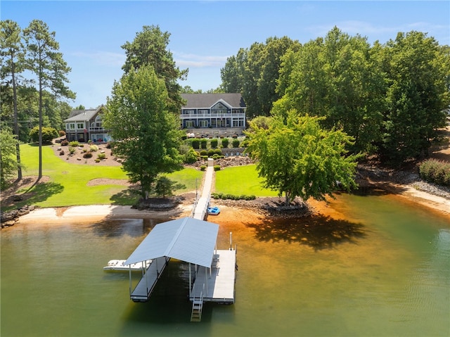 view of dock with a lawn and a water view