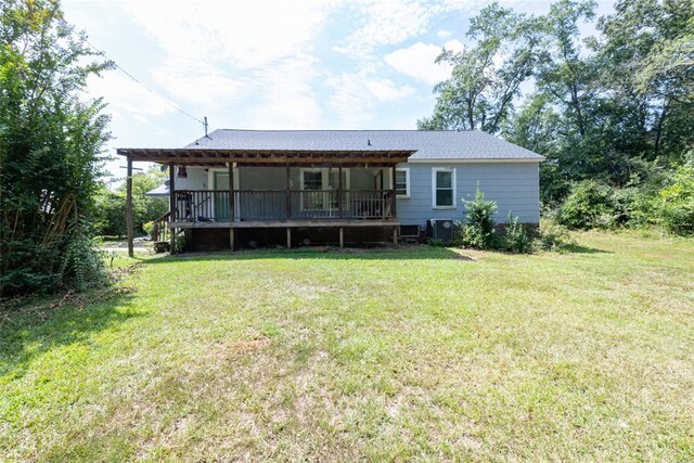 back of house with a lawn and central air condition unit