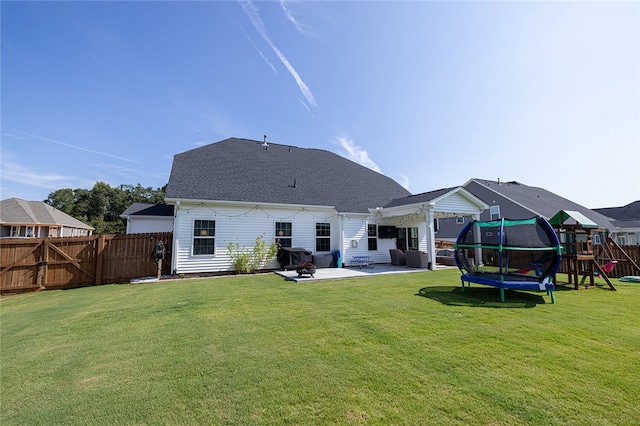 back of house featuring a lawn, a playground, a trampoline, and a patio area