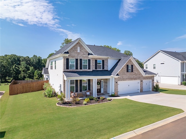 view of front of property featuring a garage, covered porch, and a front yard