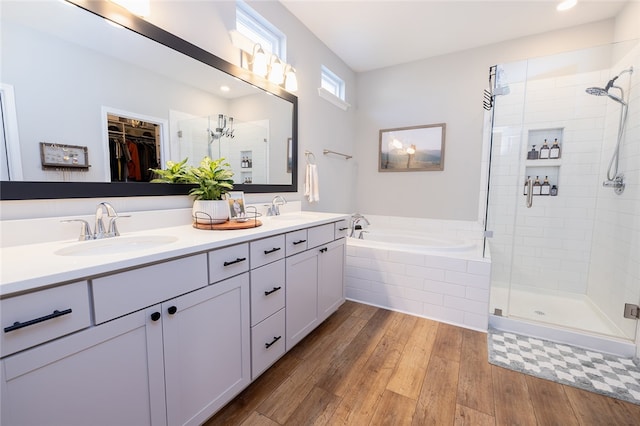 bathroom with independent shower and bath, vanity, and hardwood / wood-style floors