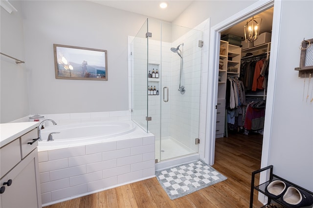 bathroom featuring vanity, separate shower and tub, and hardwood / wood-style flooring