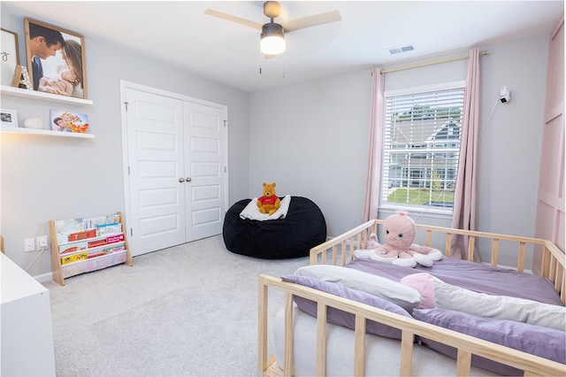 bedroom with ceiling fan, a closet, and carpet flooring