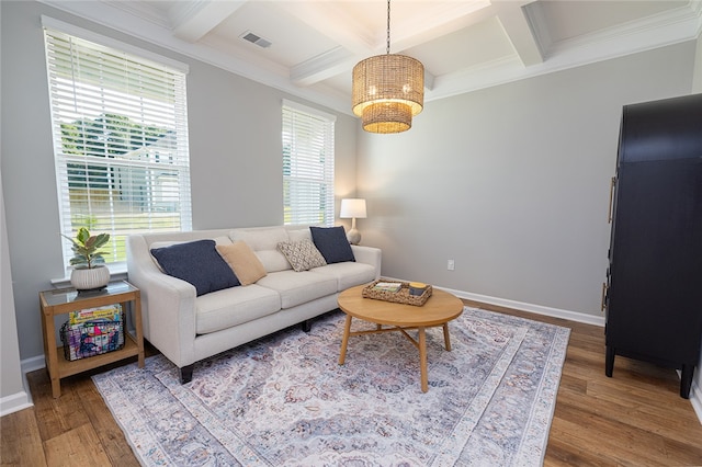 living room with coffered ceiling, hardwood / wood-style flooring, ornamental molding, and a healthy amount of sunlight