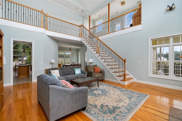 living room featuring light wood-type flooring and a high ceiling