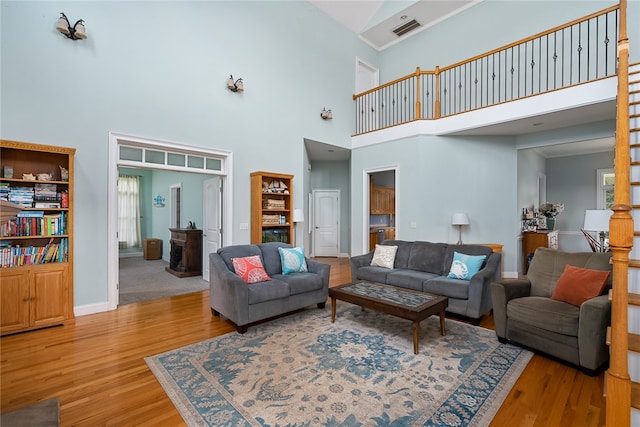 living room featuring light wood-type flooring and high vaulted ceiling