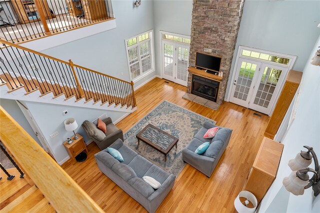 living room with french doors, a high ceiling, a wealth of natural light, and hardwood / wood-style floors