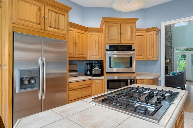 kitchen featuring appliances with stainless steel finishes, tile counters, and a kitchen island