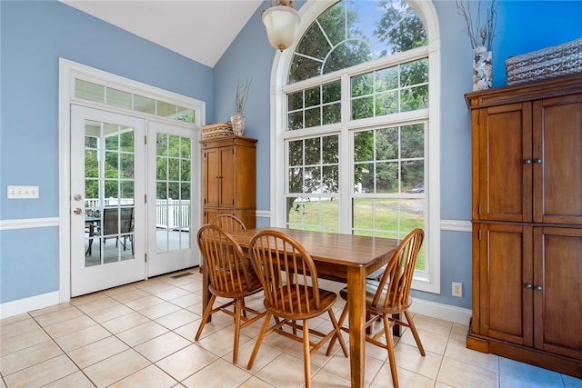 dining space featuring vaulted ceiling and light tile patterned floors