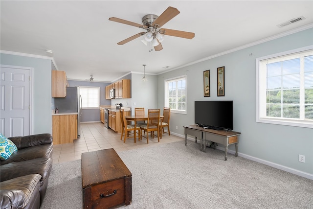 carpeted living room with ornamental molding, ceiling fan, and a healthy amount of sunlight