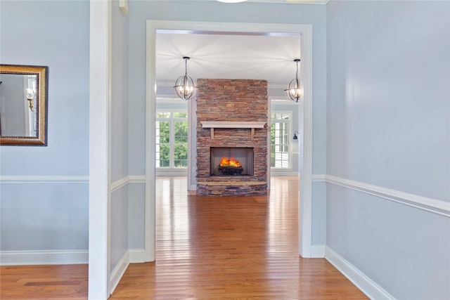 corridor with wood-type flooring and crown molding