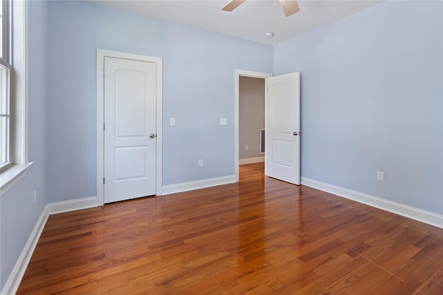 empty room with hardwood / wood-style floors and ceiling fan