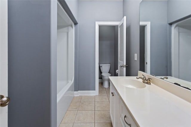 bathroom featuring tile patterned flooring, a bath, vanity, and toilet