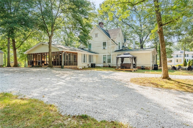 view of front of house featuring a sunroom, a gazebo, and central AC