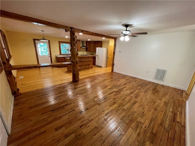 unfurnished living room with a textured ceiling, ceiling fan, and hardwood / wood-style flooring