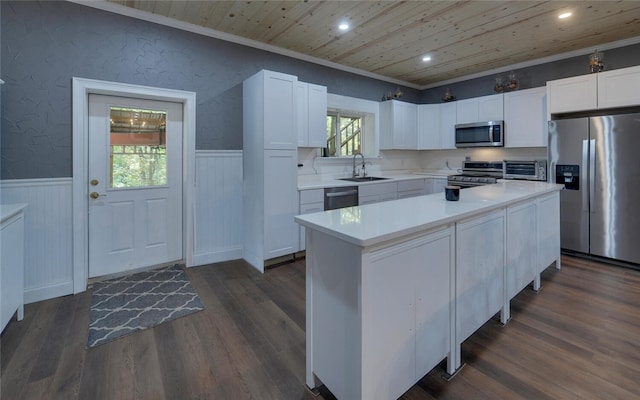 kitchen featuring stainless steel appliances, white cabinetry, a center island, and dark wood-type flooring