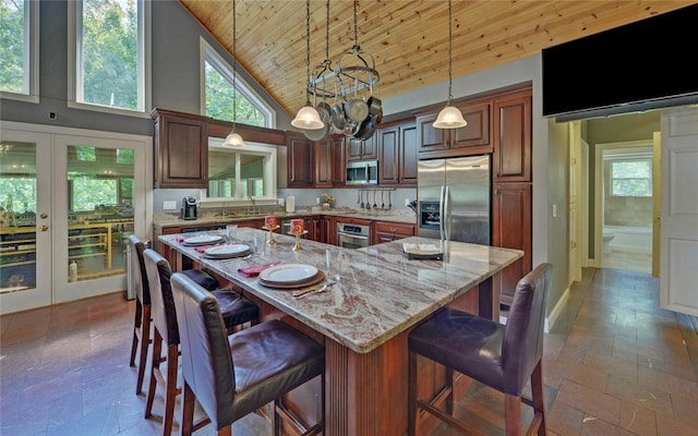 kitchen featuring a large island, hanging light fixtures, high vaulted ceiling, appliances with stainless steel finishes, and wooden ceiling