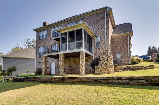 rear view of house with a yard and a sunroom