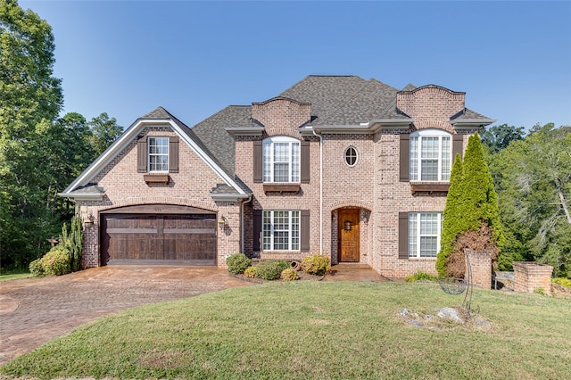 view of front of home with a garage and a front lawn