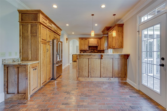 kitchen with crown molding, kitchen peninsula, pendant lighting, and high end fridge