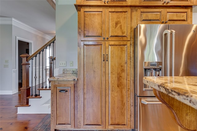 kitchen with ornamental molding, dark wood-type flooring, light stone counters, and high end fridge