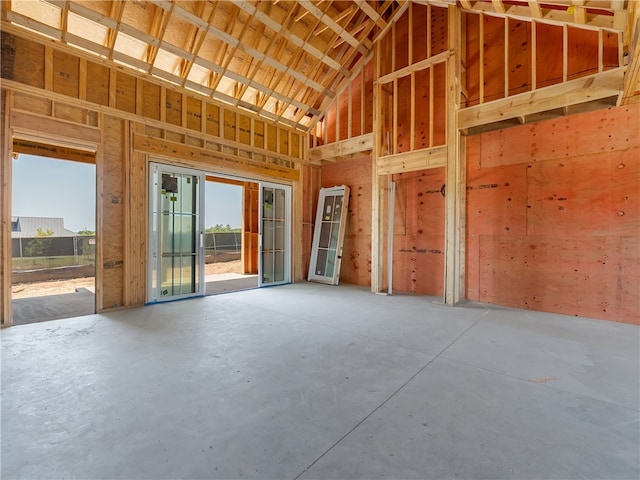 misc room featuring high vaulted ceiling and concrete flooring