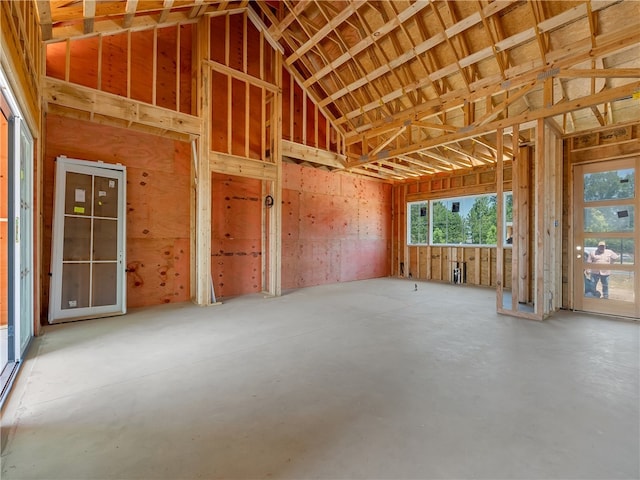 miscellaneous room with concrete flooring and lofted ceiling