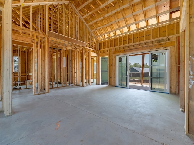 miscellaneous room with high vaulted ceiling and concrete floors