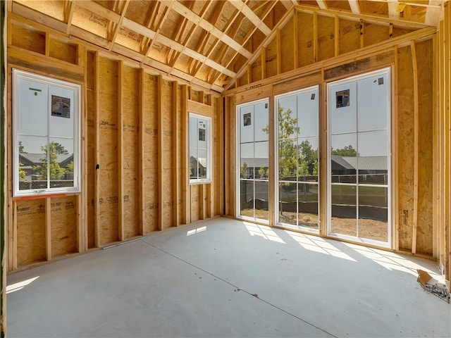 misc room with concrete flooring and lofted ceiling