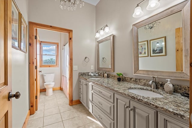 bathroom featuring an inviting chandelier, tile patterned flooring, vanity, and toilet