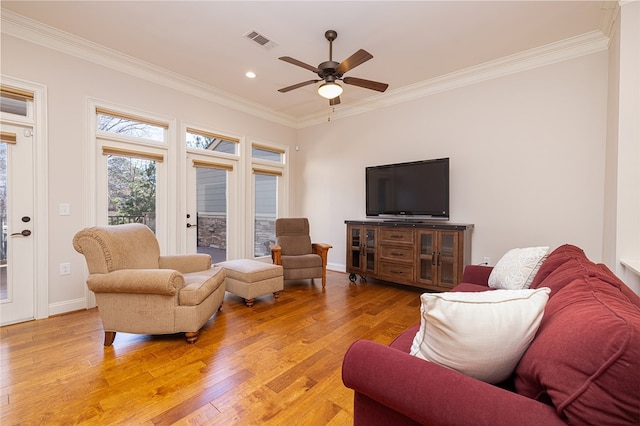 living room featuring crown molding, ceiling fan, and light hardwood / wood-style flooring