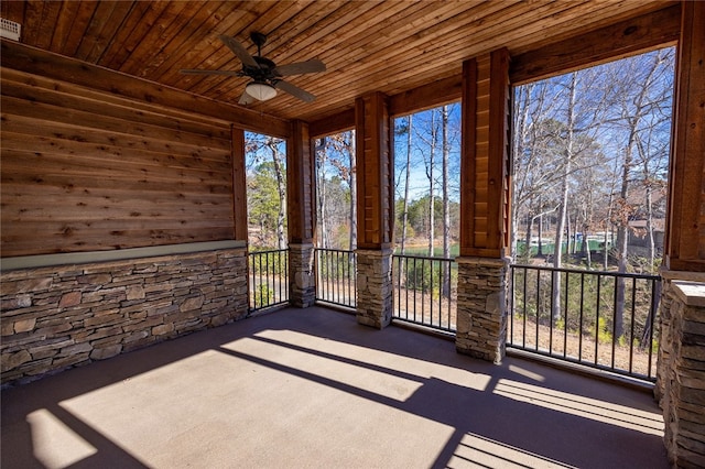 unfurnished sunroom with wood ceiling and ceiling fan