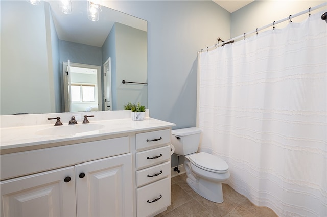 bathroom with tile patterned flooring, vanity, and toilet