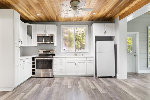 kitchen with light hardwood / wood-style floors, white cabinetry, sink, and stainless steel appliances