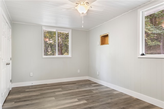 unfurnished room with ceiling fan, plenty of natural light, dark hardwood / wood-style flooring, and crown molding