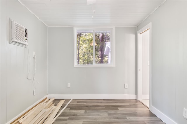 spare room featuring an AC wall unit, light hardwood / wood-style floors, and crown molding