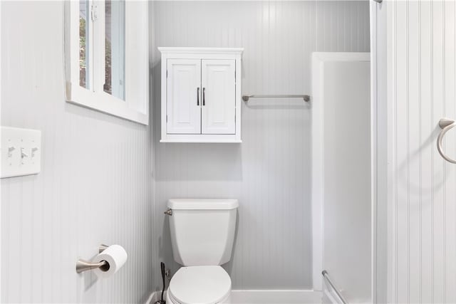 bathroom with wooden walls and toilet