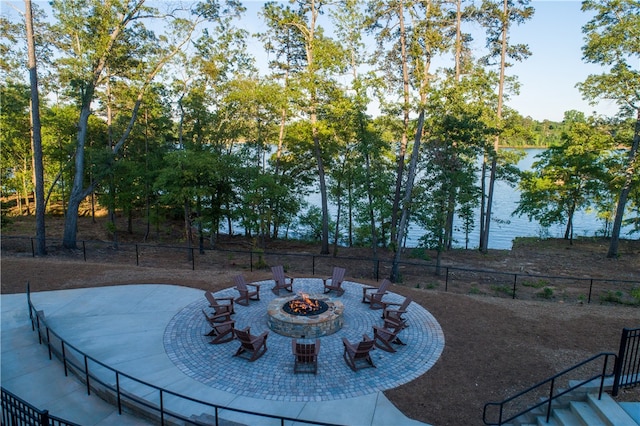 view of yard featuring a water view, an outdoor fire pit, and a patio area