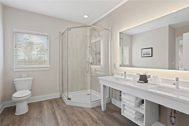 bathroom featuring hardwood / wood-style flooring, toilet, walk in shower, and sink