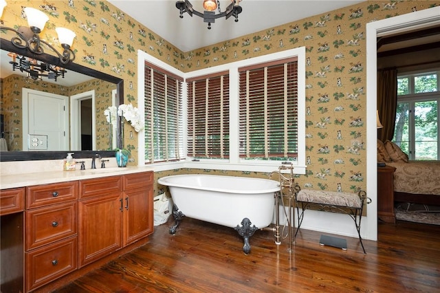 202 Passion Flower Way, Sunset, SC 29685 - bathroom with wallpapered walls, a chandelier, wood finished floors, a freestanding bath, and vanity
