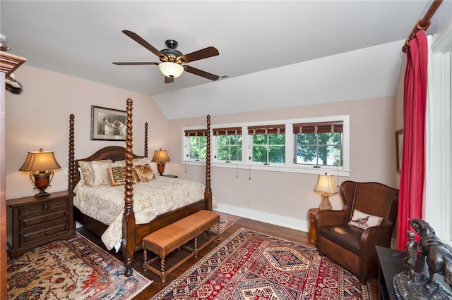 bedroom with ceiling fan, lofted ceiling, and dark wood-type flooring