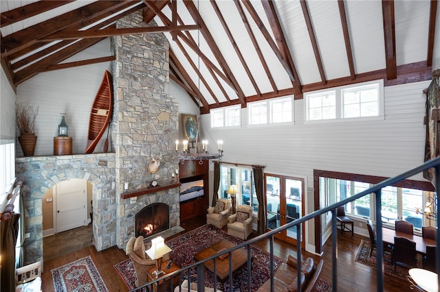 living room with a chandelier, beamed ceiling, a fireplace, high vaulted ceiling, and dark hardwood / wood-style flooring